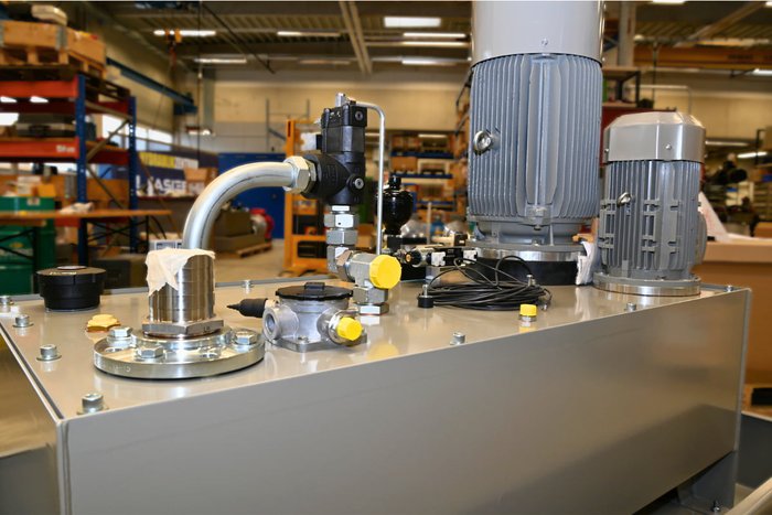 Graues Hydraulikaggregat mit Elektromotor und Ventilen in der Werkstatt